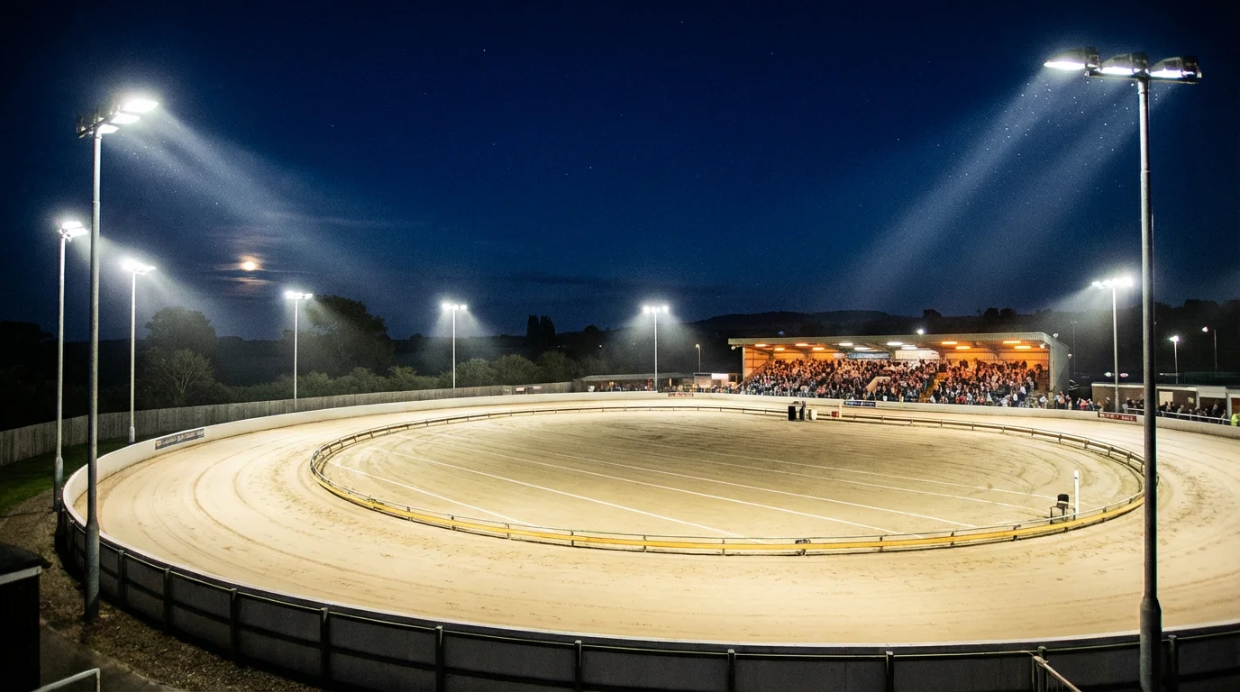 Towcester Greyhound Stadium sand track with wide sweeping bends under floodlights